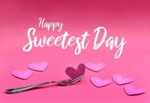 Cursive lettering that spells out Happy Sweetest Day with a bunch of cut out hearts below it