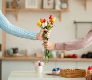 One person handing another a bouquet of flowers